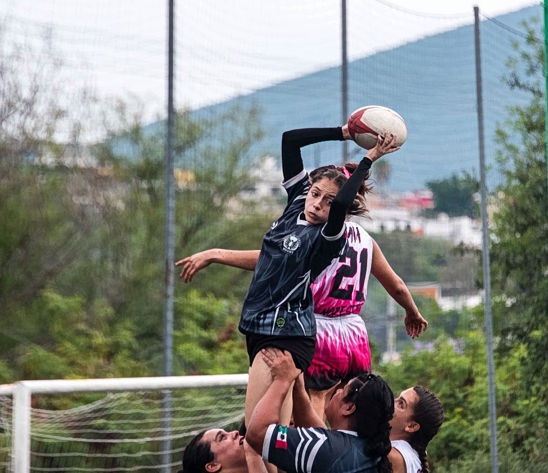 Una jugadora levantada por sus compañeras atrapa el balón en un saque de línea