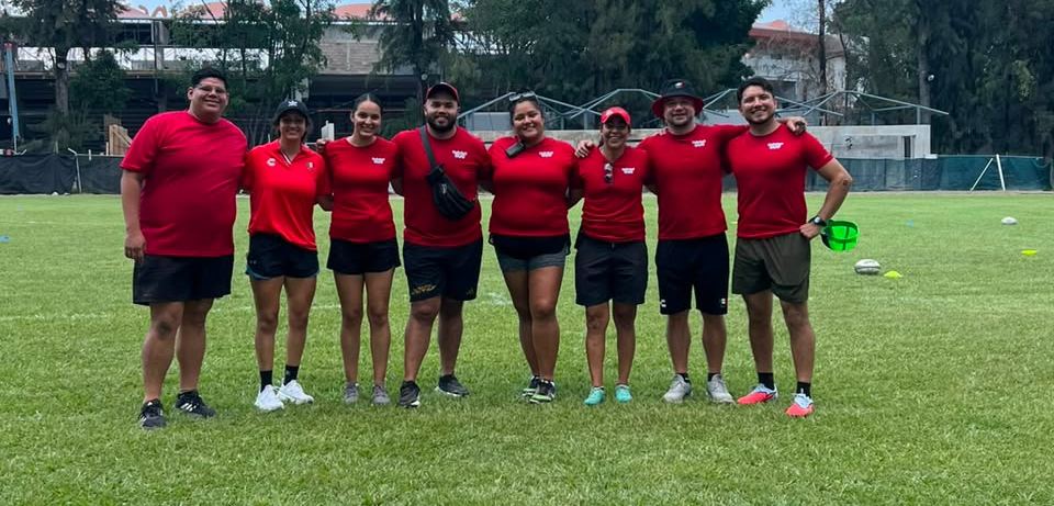 Ocho integrantes del staff posan abrazados en la cancha