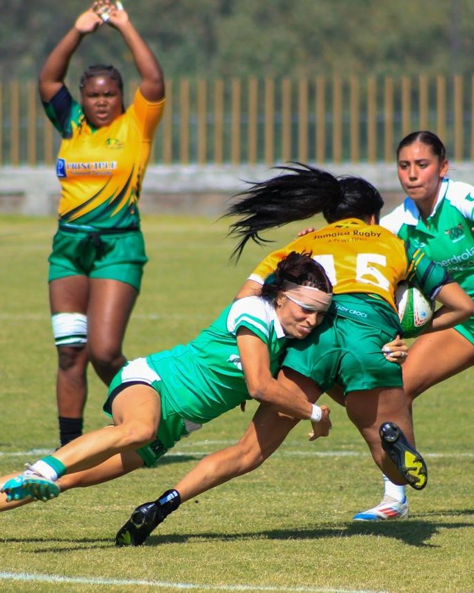 Una jugadora de la selección mexicana taclea bajo a una rival de Jamaica: hombro en el muslo, cabeza por detrás y brazos cerrando