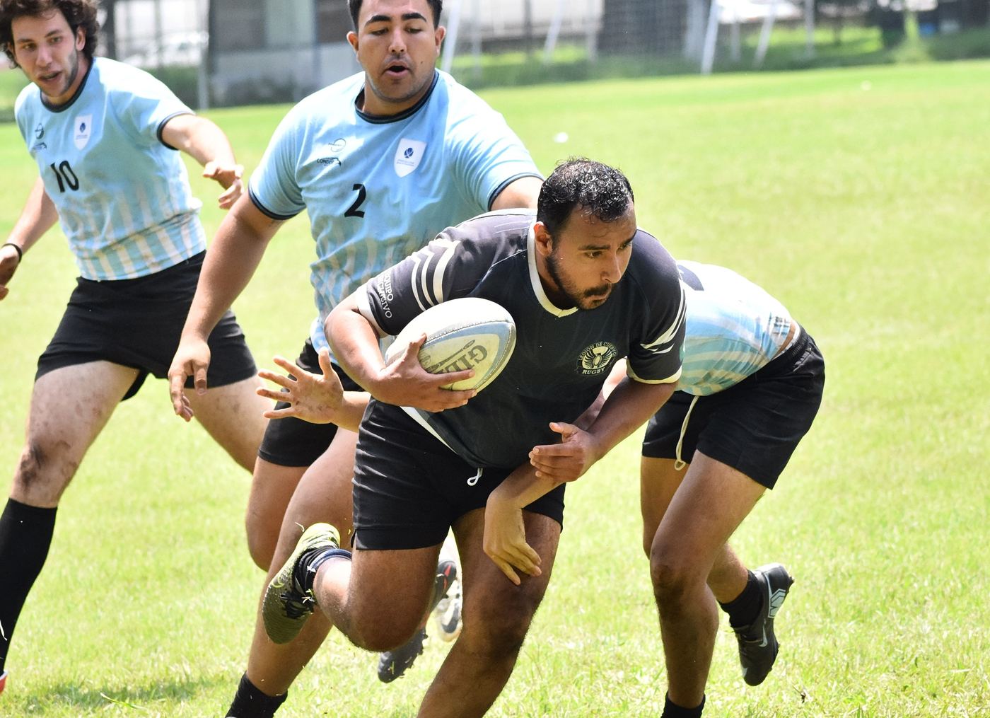 Jugador de la Legión avanza con el balón entre dos rivales